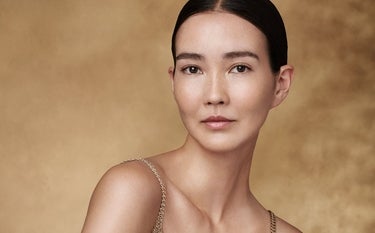 Mujer de tez radiante sobre fondo azul acuático